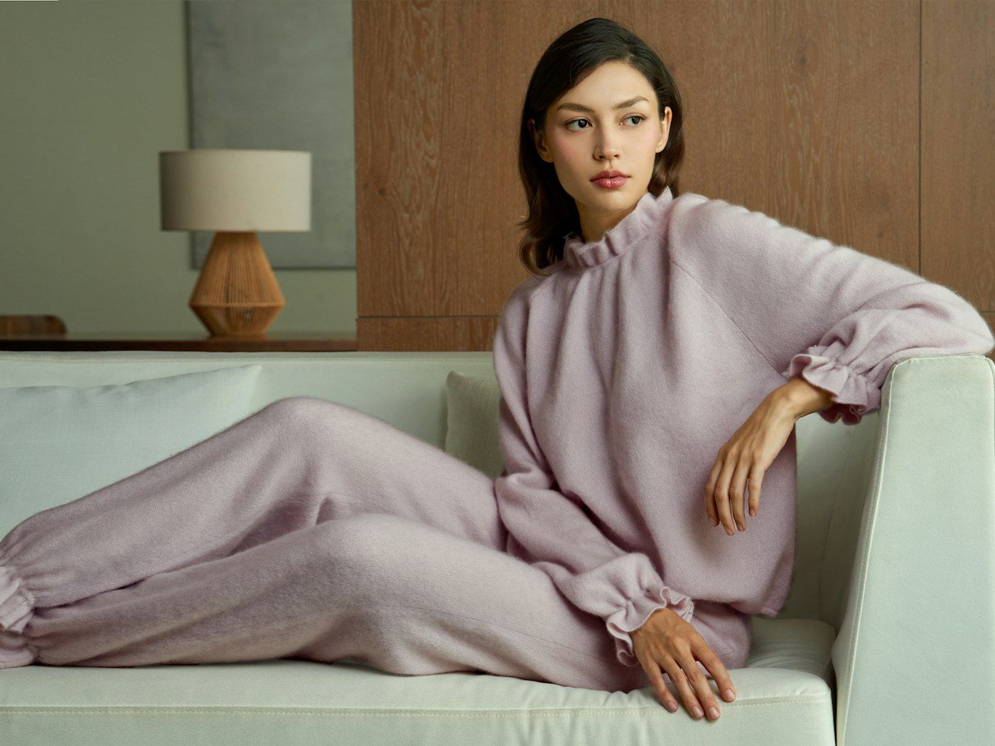 Woman relaxing on a sofa in a lavender pajama set